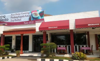 "a large building with a sign that says "" gita karbina sapadia kakkale "" and an image of a fruit" at Hotel Bandara Syariah