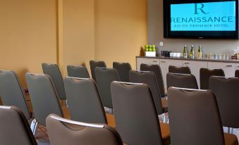 a conference room with rows of chairs arranged in a semicircle , and a tv mounted on the wall at Renaissance Aix-en-Provence Hotel