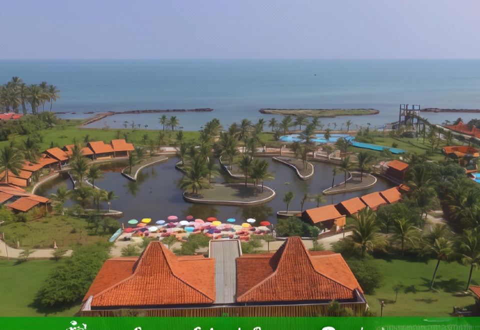 aerial view of a resort with multiple buildings , umbrellas , and a beach on the ocean at Coconut Island Carita