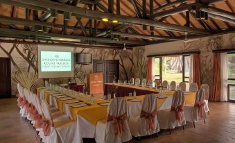 a conference room set up for a meeting , with multiple tables and chairs arranged in a semi - circle around the room at Sarova Shaba Game Lodge