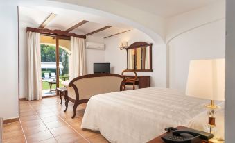 a bedroom with a large bed , television , and sliding glass doors leading to an outdoor patio at Monnaber NOU Finca Hotel & Spa