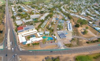 aerial view of a residential area with multiple houses , a swimming pool , and cars on the road at Discovery Parks - Townsville