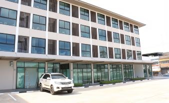 a white suv is parked in front of a modern building with large windows and glass doors at Klongyai Center