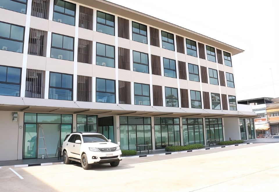 a white suv is parked in front of a modern building with large windows and glass doors at Klongyai Center