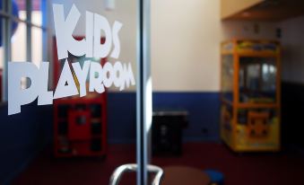 "a glass door with the words "" kids playroom "" written on it , in front of a play area" at Springwood Motor Inn