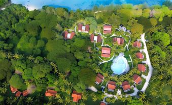 a bird 's eye view of a tropical resort with red roofed buildings and a swimming pool surrounded by lush greenery at Grand Elty Krakatoa