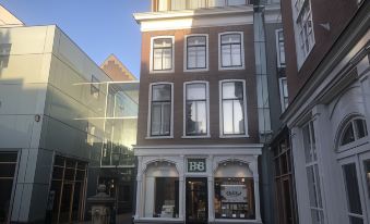 a city street with a brick building on the left side and a fountain in the middle at The Collector