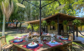 a large outdoor dining area with multiple tables and chairs arranged for a group of people to enjoy a meal at Hotel Fazenda Sete Lagos