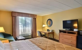 a hotel room with a bed , desk , and window , along with other amenities such as a tv and desk at Hotel Veranda DuBois