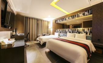 The bedroom features two beds and a large flat-screen TV positioned in the center at Hotel Zenith