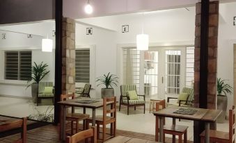 a large , open room with wooden tables and chairs , and a checkerboard table in the center at Urban Lodge