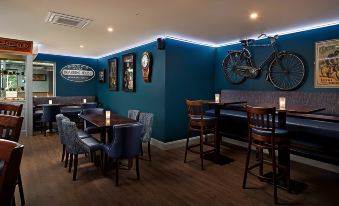 a restaurant with blue walls , wooden tables , and chairs , and a bicycle mounted on the wall at Shannon Springs Hotel