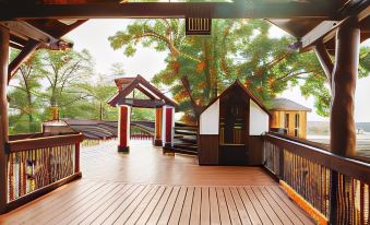 a wooden deck with a thatched roof and a view of the trees and sky at Heritage Hotel Lancaster