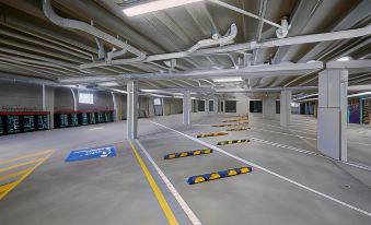 a large , empty warehouse with a white ceiling and gray floor , surrounded by blue and yellow tiles at East Maitland Executive Apartments