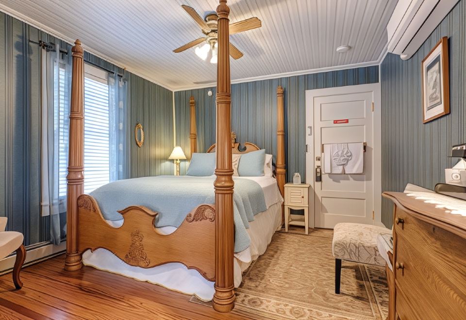 a bedroom with a wooden bed , white walls , and a ceiling fan , surrounded by blue walls at Broad River Inn