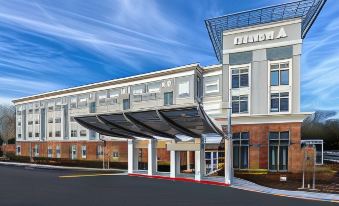 "a large building with a covered entrance and a sign that reads "" inman & associates "" on it" at Cambria Hotel West Orange