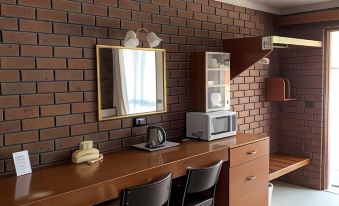a brick wall with a wooden desk and chairs in front of a window , creating a cozy atmosphere at Econo Lodge Lilydale