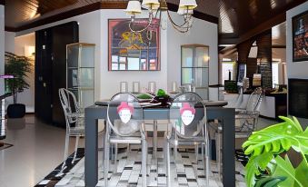 a dining room with a wooden table , chairs , and a painting on the wall , along with a chandelier hanging above the table at Hotel Monaco