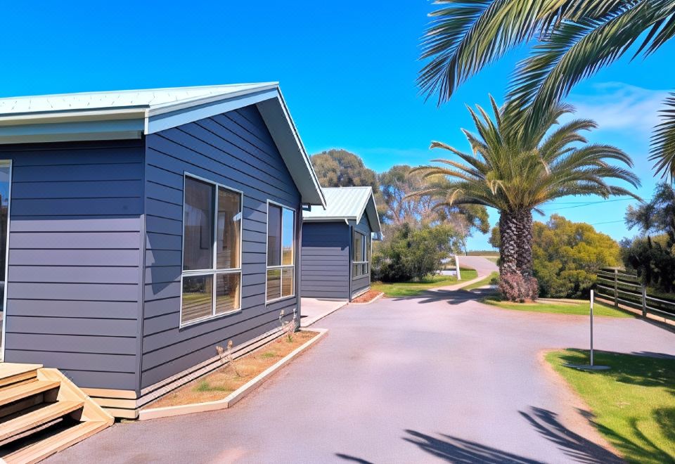 a row of gray houses with palm trees in the background , creating a picturesque scene at Seahorse Coastal Villas