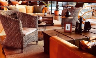 a modern living room with wooden furniture , including couches , chairs , and a coffee table , arranged around a central area at Quest Breakfast Creek