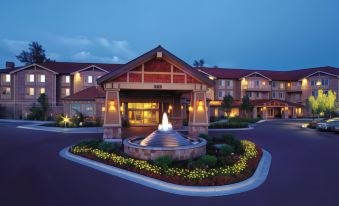 a large building with a fountain in front of it , surrounded by trees and grass at Hilton Garden Inn Boise/Eagle