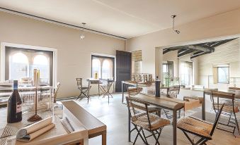 a dining room with a wooden table , chairs , and a couch , all set up for a meal at Castello di Gabiano