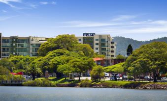 "a large building with the sign "" fulda "" is surrounded by trees and water , with a blue sky in the background" at Quest Breakfast Creek