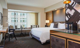 a large bed with white linens is in a hotel room next to a window at Renaissance Allentown Hotel