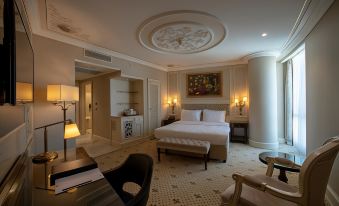 a luxurious hotel room with a large bed , a piano in the corner , and various furniture items on the walls at DoubleTree by Hilton Gaziantep