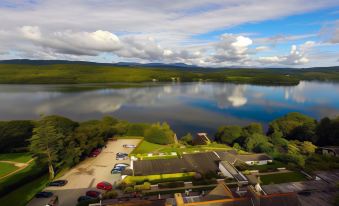 a large body of water with a small island in the middle , surrounded by trees and houses at Beech Hill Hotel & Spa