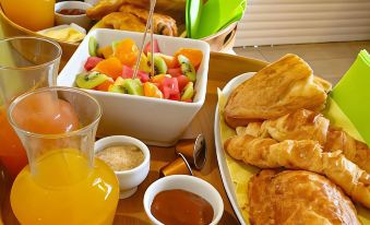 a dining table filled with a variety of food items , including bread , fruit , and various condiments at Majesty Palm