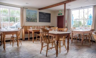 a dining area with wooden tables and chairs , as well as a chalkboard on the wall at The Golden Key