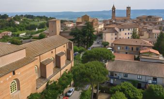 a bird 's eye view of a town with buildings , trees , and cars parked in the lot at Hotel Vannucci