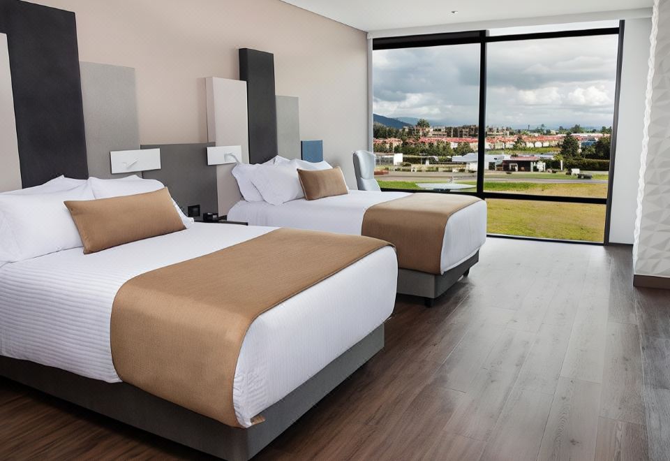 a hotel room with two beds , one on the left and one on the right side of the room at Hotel Sabana Park