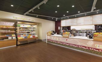 a large , well - lit convenience store with a variety of food items on display and a refrigerated display case stocked with fresh produce at Days Inn by Wyndham Taunton