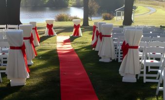 a red carpet with white chairs and red ties is set up in a grassy area at Susquehanna Manor Inn