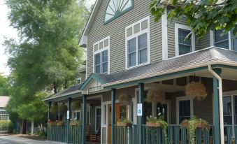 "a building with a porch and potted plants in front , labeled "" exxon gas station "" on the side" at The Craftsman Inn & Suites