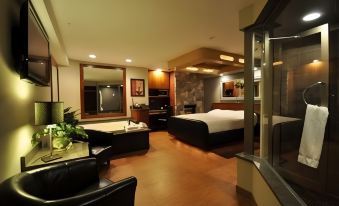 a hotel room with a king - sized bed , a bathroom with a bathtub , and a dining area at The Champagne Lodge & Luxury Suites