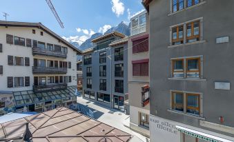 "a view of a city street with buildings and mountains in the background , and a sign that reads "" südtirol ""." at Hotel Heimatlodge