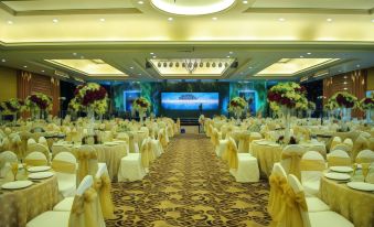 a large banquet hall with multiple tables and chairs , decorated for an event or celebration at Crown Victoria Hotel Tulungagung