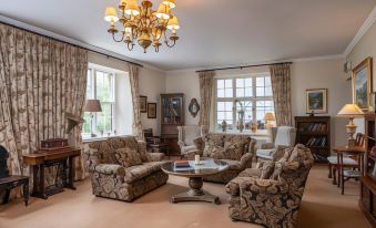 a large living room with multiple couches and chairs arranged in various positions , creating a cozy and inviting atmosphere at Abbeyglen Castle Hotel