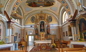 a large , ornate room with a high altar and paintings on the walls is shown at VeLa