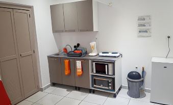 a small kitchen with a microwave , toaster oven , and other appliances on a gray countertop at Vichy