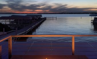 a sunset view from a deck overlooking a body of water , with a fire pit in the foreground at Lakeside Inn