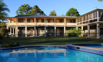 a large apartment building with multiple balconies and a swimming pool in front of it at Bucketts Way Motel