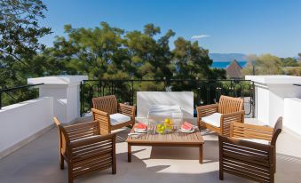 a patio with a dining table and chairs , surrounded by a beautiful view of the ocean at Mitsis Galini