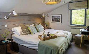 a large bed with a tray placed on it is in a room with wooden walls and a window at Lock Chambers, Caledonian Canal Centre