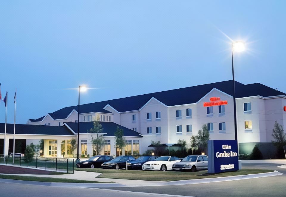 a hilton garden inn hotel with its name displayed in large letters above the entrance , surrounded by cars and streetlights at Hilton Garden Inn Chesterton