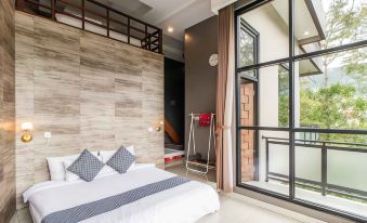 a modern bedroom with a white bed , wooden headboard , and large windows that offer views of the outside at Van House