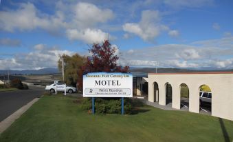 "a car is parked in front of a hotel with a sign that says "" evolution valley century inn motel ""." at Mountain View Country Inn